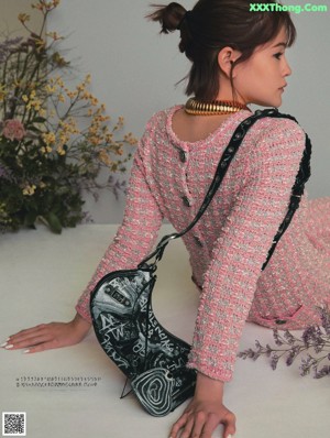 A woman sitting on a chair in front of a bunch of flowers.