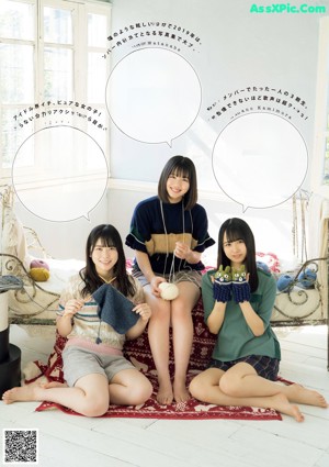 A group of young women sitting on top of a lush green field.