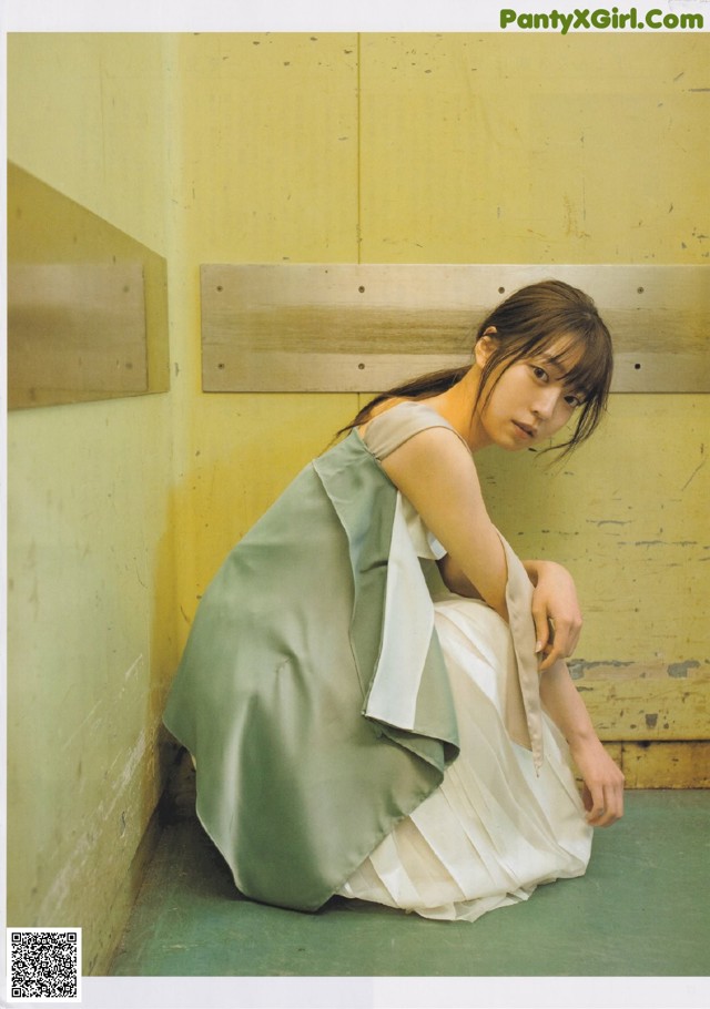 A woman sitting on the floor in a room.