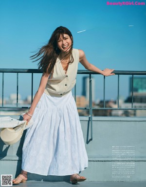 A woman sitting on a bench in front of a city skyline.