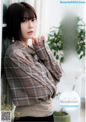 A woman in a white blouse sitting on a chair.