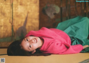 A pink sweater laying on top of a wooden table.