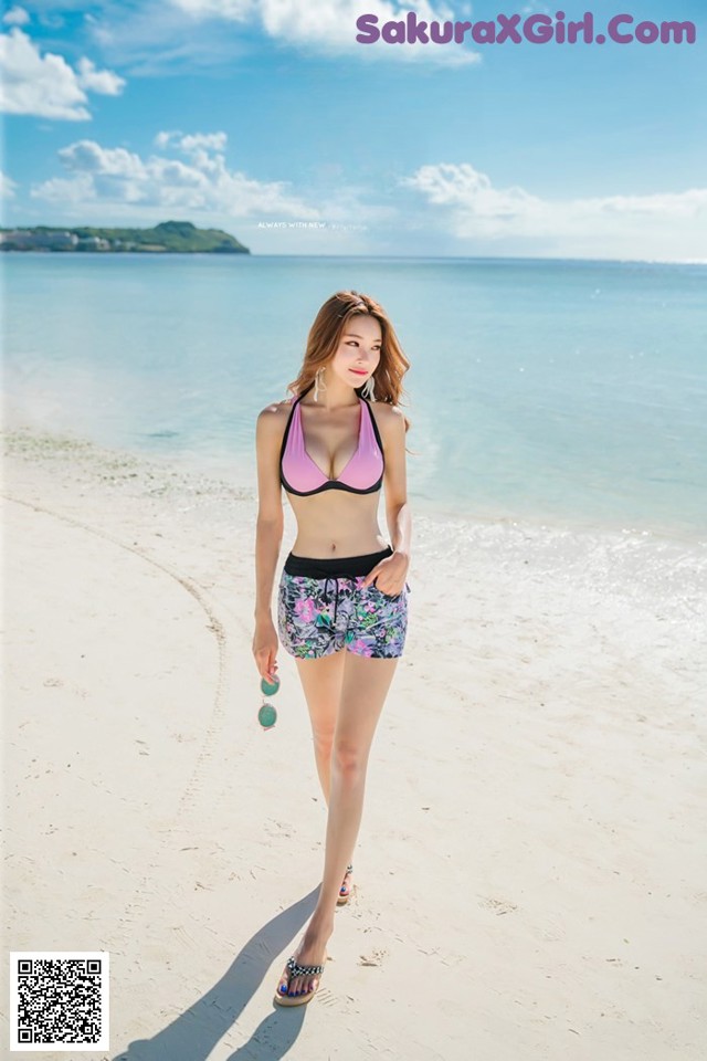 A woman in a bikini standing on a beach.