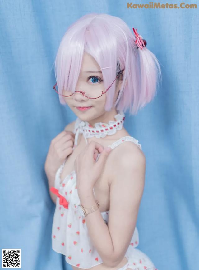 A woman with pink hair and glasses posing for a picture.