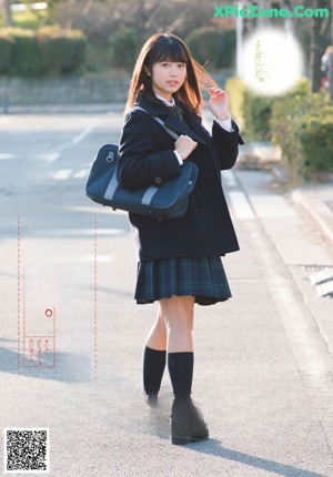 A woman in a school uniform is posing for a magazine cover.