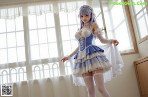 A woman in a blue and white dress standing by a window.