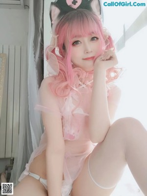A woman with pink hair wearing a nurse outfit.