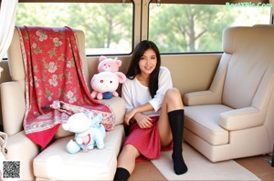 A woman in a plaid shirt and white panties sitting in a car.