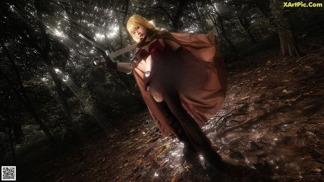 A woman in a red dress holding a sword in a forest.