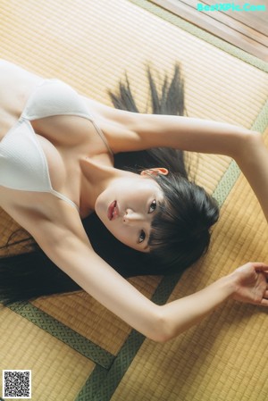 A woman sitting on the floor in front of a mirror.