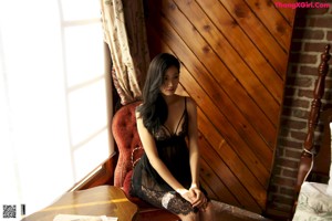 A woman standing in a bedroom next to a bed.