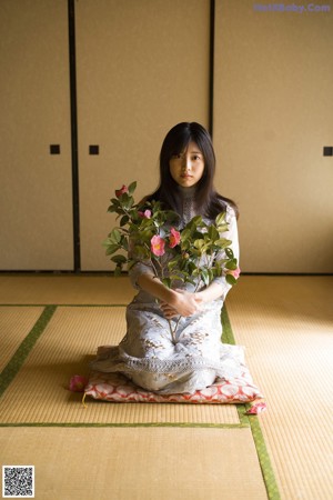 A woman laying on the floor with a flower in her hand.