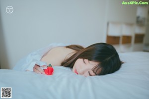 A woman in a red and white bikini sitting on a bed.