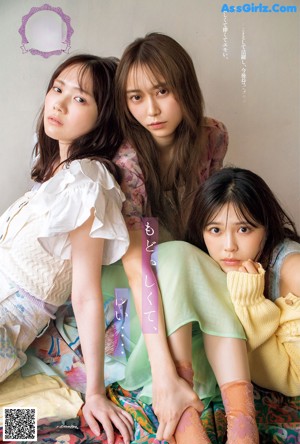 A group of young women laying on top of a bed.