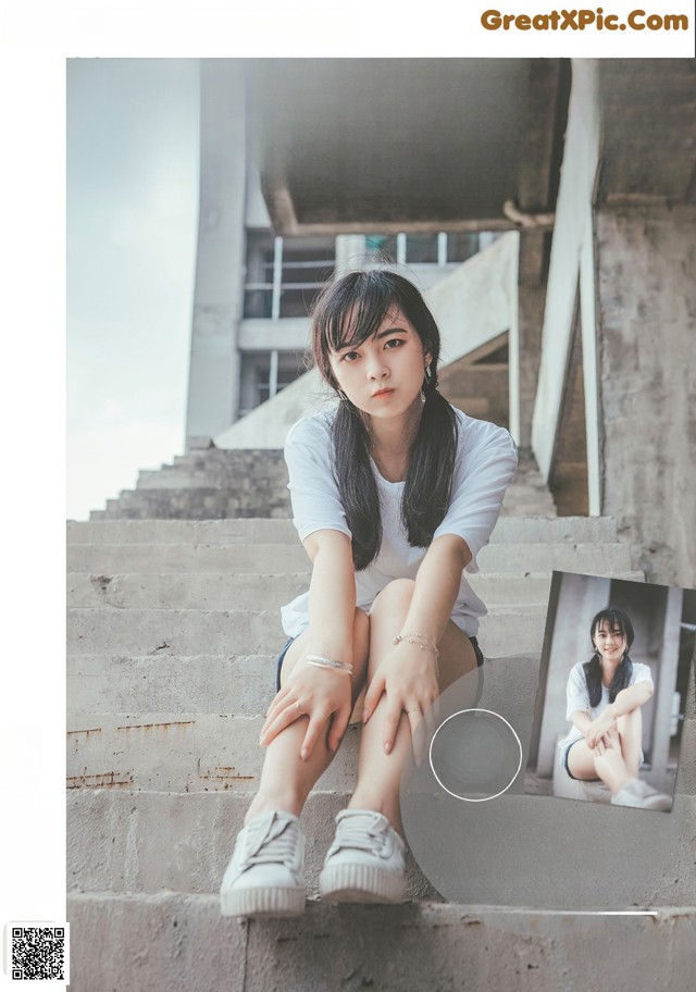 A woman sitting on the steps of a building.