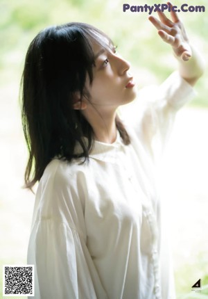 A woman in a blue and white dress standing on a wooden bridge.