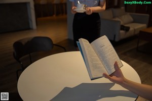 a woman sitting at a table with her legs crossed