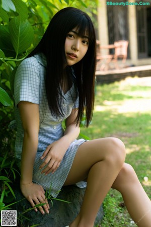 A woman with long black hair wearing a black bra.