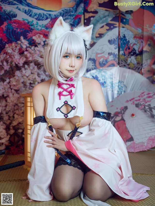 A woman in a kimono sitting on the floor with an umbrella.