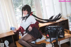 A woman sitting on the floor in a classroom.