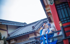 A woman in a blue dress sitting on the floor.