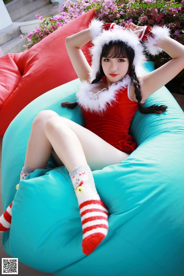 A woman in a red and white outfit sitting on a bean bag chair.