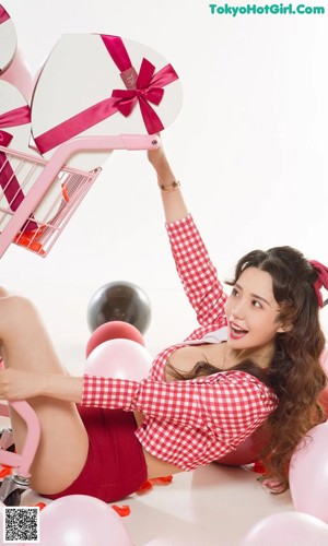 A woman in a red and white checkered bikini holding a rose.