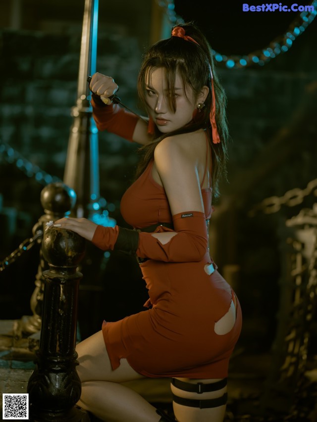 A woman in a red dress holding a sword.
