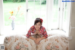 A woman in a red and white bathing suit laying on a couch.