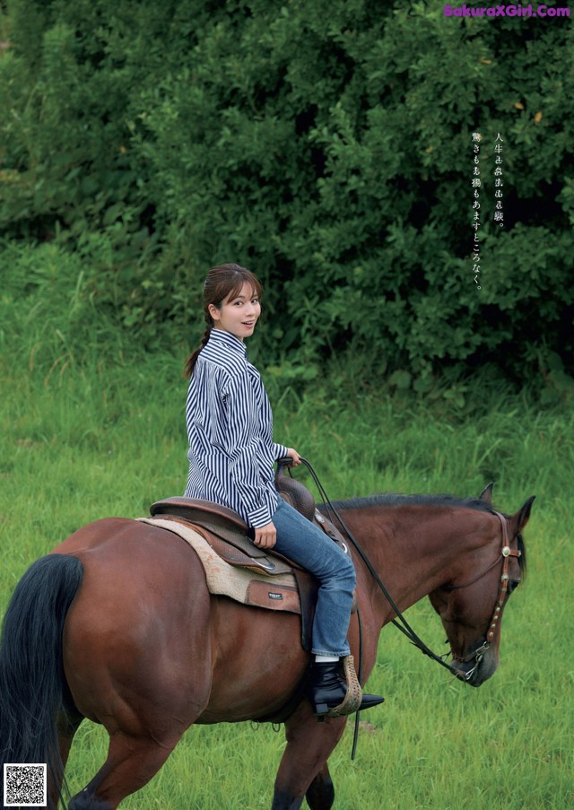 A woman riding on the back of a brown horse.