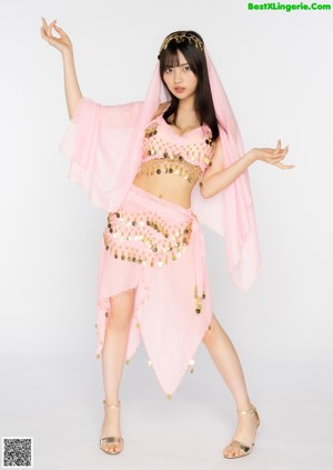 A woman in a purple belly dance outfit posing for a picture.