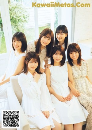 A group of young women sitting on top of a bed.