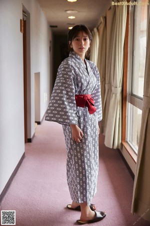 A woman in a kimono looking up at a ruler.