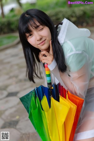 A woman in a raincoat holding an umbrella.