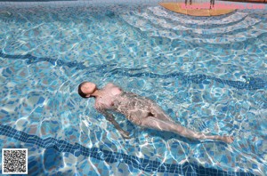 A woman in a blue bikini floating in a pool.