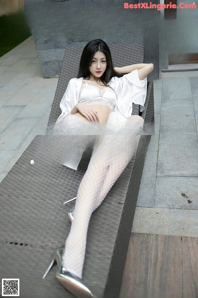 A woman in fishnet stockings is sitting on a bench.