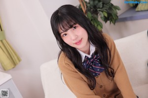 A young woman sitting on top of a white couch.